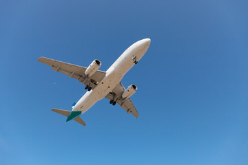 Fototapeta premium samolot pasażerski lecący na błękitnym niebie.