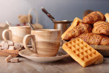 Breakfast with black coffee and fresh pastries.