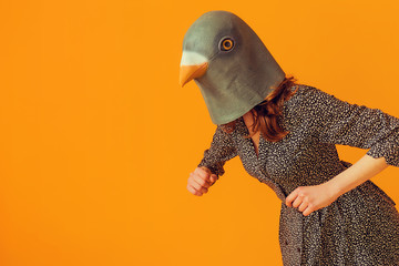 Woman portrait wearing pigeon mask and doing chicken imitation