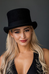 Beautiful and lovely woman wearing top hat and smiling