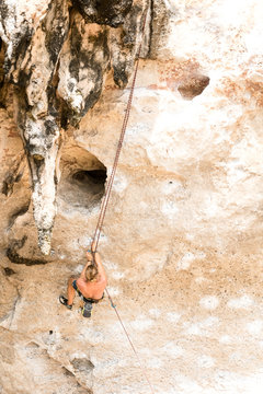 Young man climbing on a limestone cliff in Railay Beach Krabi, Thailand