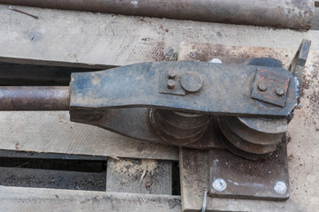 Old hand tool for bending pipe is fixed on a tree