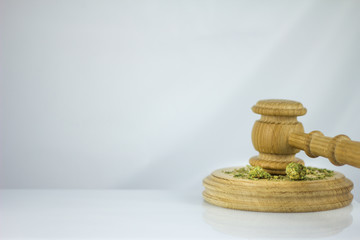 Wooden judge hammer with sound block on the white mirror background - Legality of cannabis, legal and illegal cannabis on the world.
