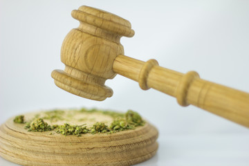 Wooden judge hammer with sound block on the white mirror background - Legality of cannabis, legal and illegal cannabis on the world.