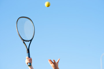 Tennis racket in hand and ball  