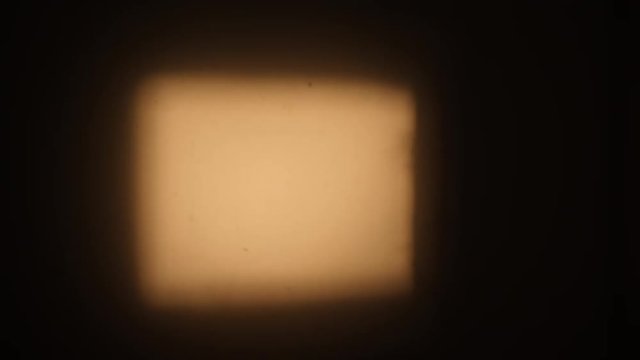 Blank 8mm film projected on wall.