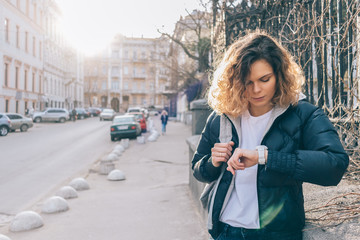 Fototapeta premium Young woman waits meeting and checks time