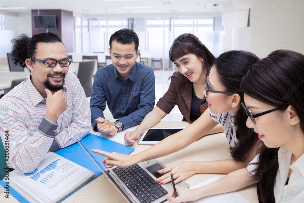 Wall mural Young business people discussing in the boardroom