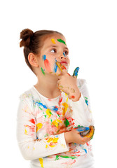 Pensive girl with hands and face full of paint isolated on a white background