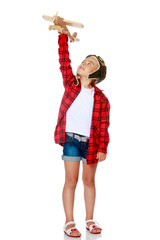 Little girl with a wooden plane in her hand.
