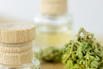 Medical Oil Cannabis - marijuana flowers on the wooden stopper with cannabis oil  bottles.
