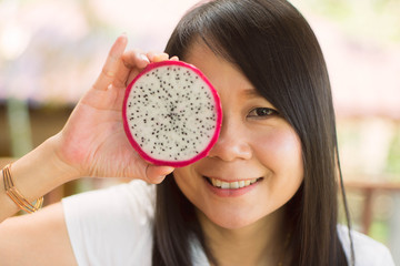 Asian woman holding dragon fruit  with happy.