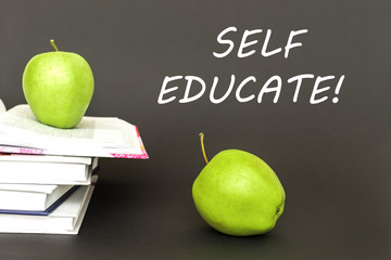 text self educate, two green apples, open books with concept