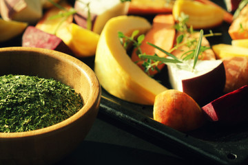 Pan full of fall seasonal vegetables ready to be grilled over a dark background
