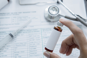 Anonymous male doctor holding a vial of medicine
