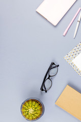 Flat lay home office desk. Female workspace with note book, eyeglasses, tea mug, diary, plant. Copy space