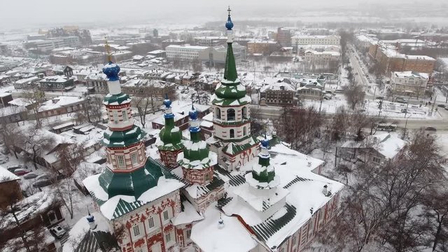 Beautiful winter flight above old Russian city Siberia. Church of the exaltation of the Holy cross of the God Irkutsk. Tourist religion attraction. Snow roofs  old wooden houses. Aerial drone 4k