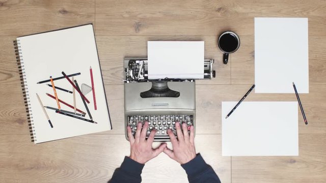 Book writing by the window with a vintage typewriter. 4K video colors and black and white