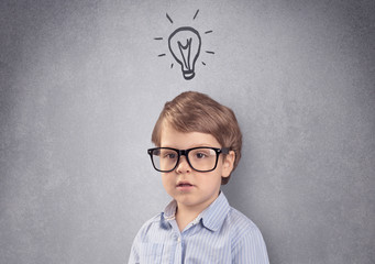 Smart little junior in front of a drawn up grey wall with childlike concept