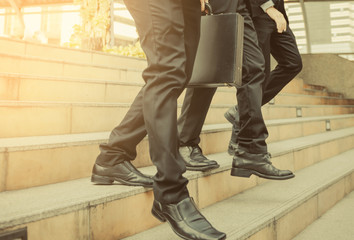defocused or blured Businessman walking the stairs with city background, Businessmen go to success concept, vintage style.