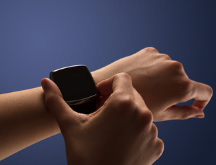 Close up female hand with smartwatch and dark background and black screen