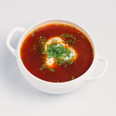 Homemade soup served in a white bowl on a white background