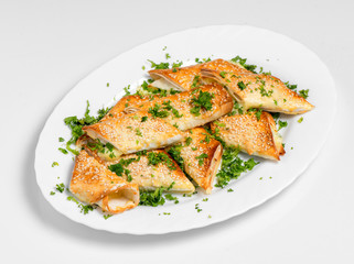 A puff pastry pie with cheese coated with sesame seeds