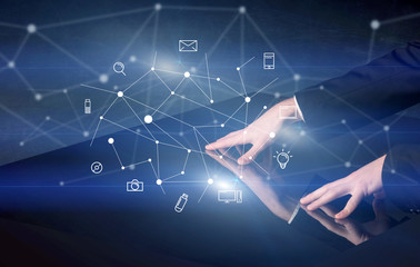 Male hands touching interactive table with blue mixed communication icons in the background