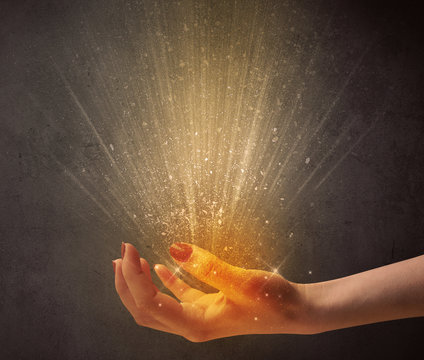 Yellow ray of light coming from a young hand 