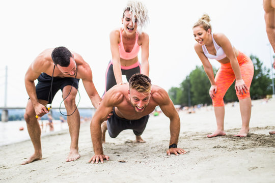 Group Of Young Attractive People Having Fun At Beach And Doing Some Fitness Workout. 