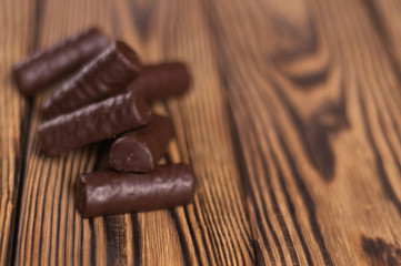 Heap of yummy chocolate candies on old weathered wooden table. With copy space