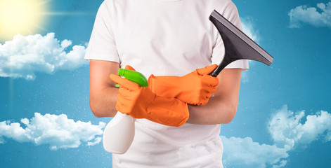 Sunny and cloudy concept with male housekeeper and orange gloves on his hand
