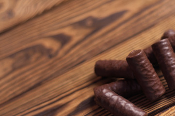 Heap of yummy chocolate candies on old weathered wooden table. With copy space
