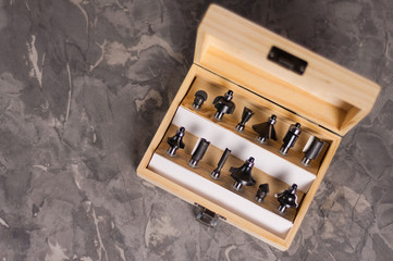 Set of steel router bit for milling cutter in rectangle wooden box with metal lock on old broken...