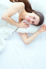 Obraz na płótnie Canvas Pretty woman lying down on her bed at home
