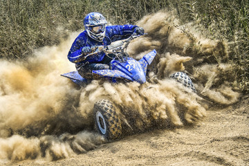 ATV rider creates a large cloud of dust and debris