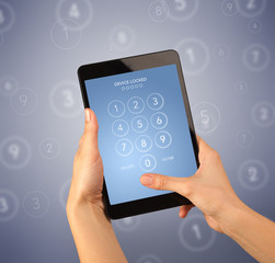 Female fingers touching tablet with locked device requiring passcode