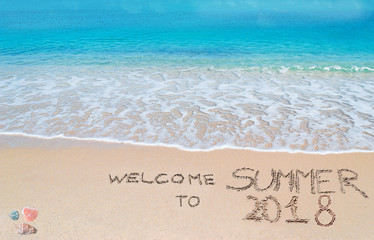 welcome to summer 2018 written on a tropical beach