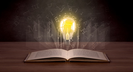 Shiny alphabet letters and yellow lightbulb hovering over open book 