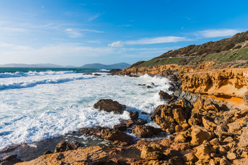 Fototapeta na wymiar Waves by Alghero rocky coast