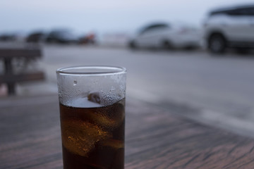 A grass of soft drink on wood table. Lonely concept. Soft drink background.