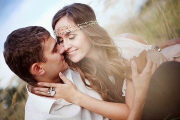 Portrait of beautiful young couple hugging in the gold field. Happy family. Pretty woman and handsome man in love on nature. Sweethearts. Love story