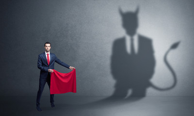 Businessman standing with red cloth in his hand and devil shadow on the background
