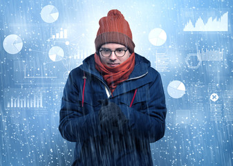 Young businessman shivering with graphs, reports and chart concept
