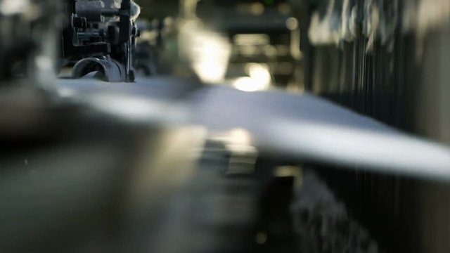 Сlose-up of the process fabric creation on a modern weaving loom in a factory