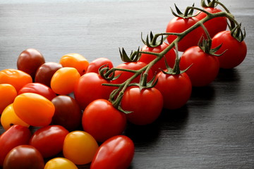 Group of cherry tomatoas on black board, high angle view, close up