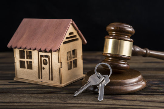 wooden house, keys, judge hammer on a wooden background. housing law. lawyer, court. Bidding, buying, selling, auction