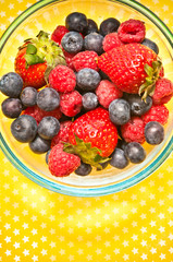 fruit raspberries, blueberries and strawberries berries in blue bowl 