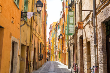 Fototapeta na wymiar narrow street with colorful houses in Menton, cote d'azur, french riviera, France