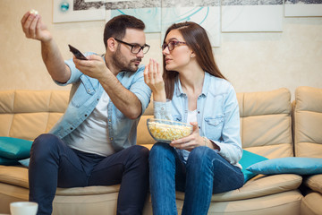 Amazed couple watching tv program